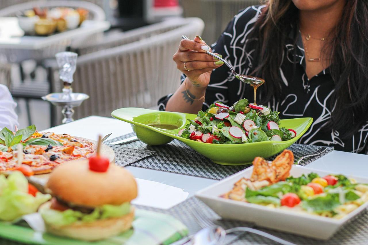 Majestic Arjaan By Rotana - Manama Aparthotel Ngoại thất bức ảnh A woman seasoning a salad
